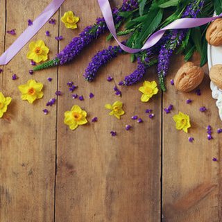 Spring flowers, walnuts and ribbon on a wooden table