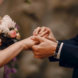 Groom placing a wedding ring on the bride's finger